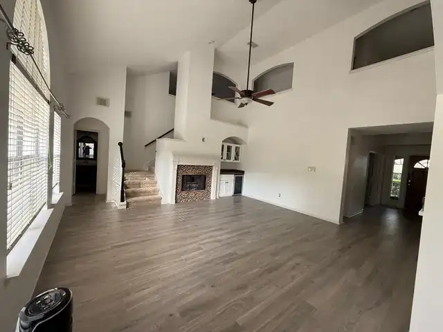 Finished living room with vaulted ceiling and wood-look flooring