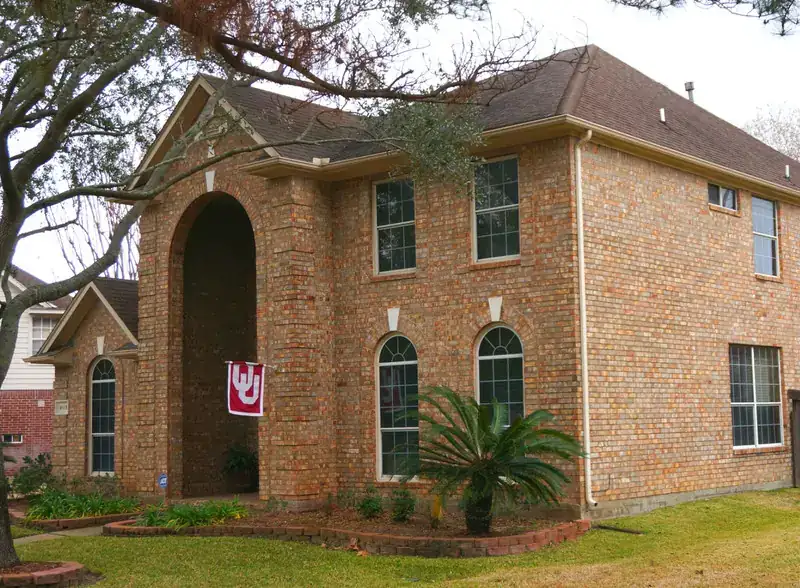 Residential brick home with completed roofing work