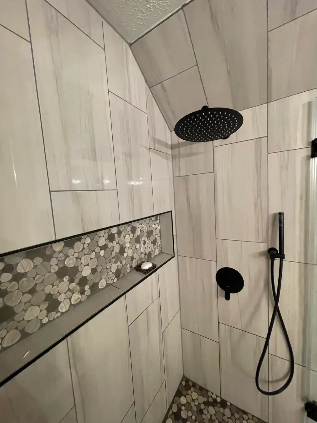 Completed walk-in shower remodel with black rain shower head